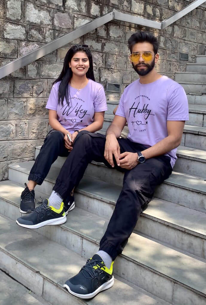Real-life couple wearing Matchy customized couple tees on their anniversary posing on stairs