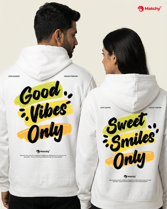 couple hoodies with prints 'Good vibes only' & 'Sweet smiles only' worn by a couple in white color, back view.