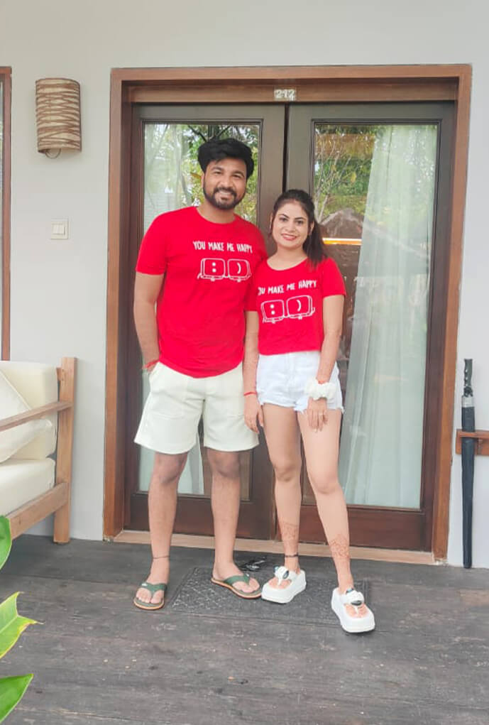Real-life couple wearing Matchy couple tees on their honeymoon posing outside their beach villa
